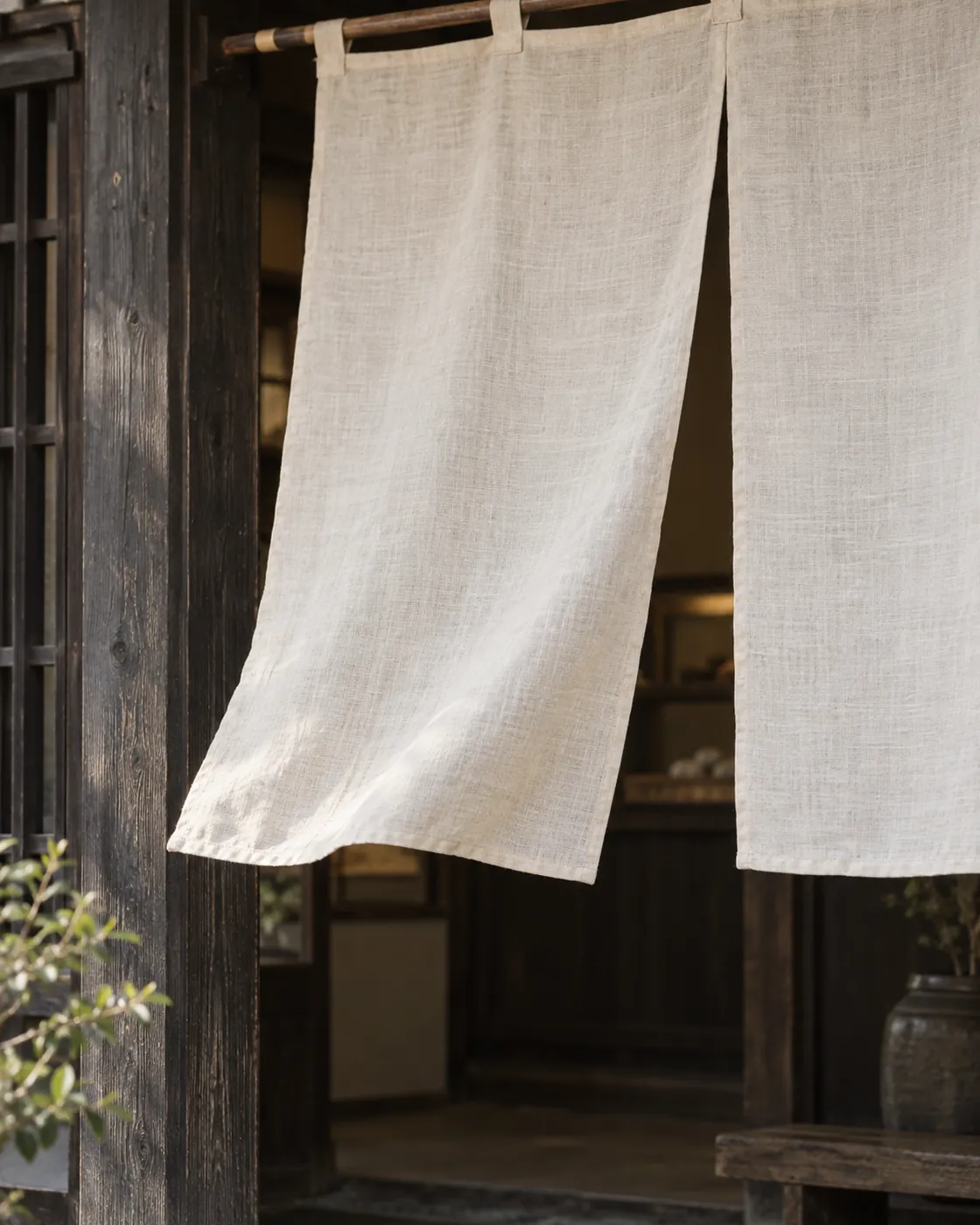 生成りの暖簾が掛かった、木の格子の店の入口